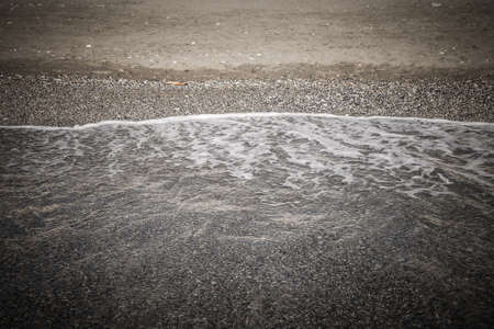 Wave on the pebble coast of sea. Selective focus. Toned.の写真素材