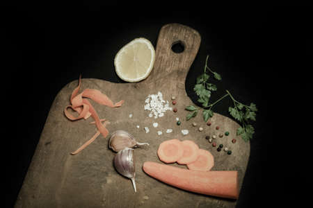 Salt, pepper and vegetables on old wood background. Toned.の写真素材
