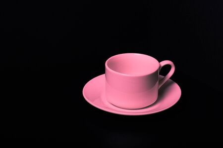 Cup and saucer on a black background. Toned.の写真素材