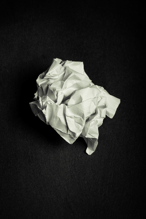 Crumpled paper on black slate cutting board. Toned.の写真素材