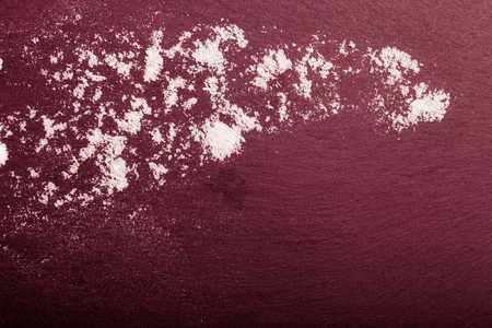 Flour spilling on color background of slate cutting board. Toned.の写真素材