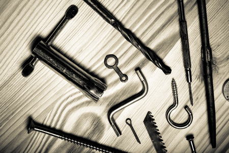 The contents of the old toolbox on light wooden background. Top view. Toned.