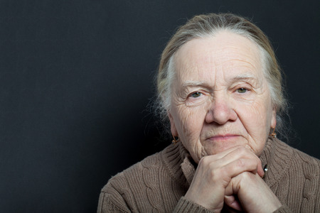 Portrait of elderly woman on dark background.の写真素材