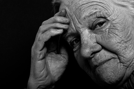 Portrait of elderly woman on dark background. Toned.の写真素材