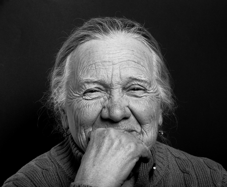 Portrait of elderly woman on dark background. Toned.の写真素材