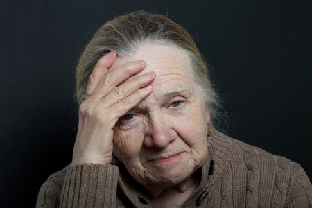 Portrait of elderly woman on dark background.の写真素材