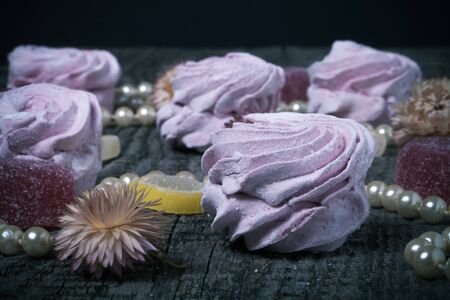 Fresh pink homemade zephyr - marshmallow on old wooden table. Shallow depth of field. Toned.の写真素材