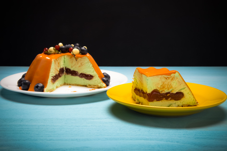 Orange mousse cake with berries n the blue wooden table. Toned.の写真素材