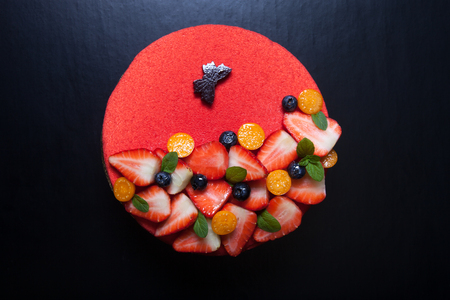 Many fresh berries on bright mousse cake.の写真素材