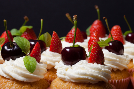 Fresh cupcakes with cream and berries. Shallow depth of field. Selective focus.の写真素材