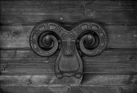 Cast iron ornament on a light wooden wall. Toned.の写真素材