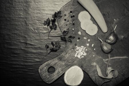 Salt, pepper and vegetables on old wood background. Toned.の写真素材