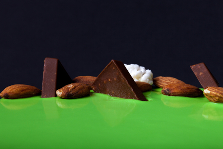 Green mousse cake with nuts and chocolate pieces.の写真素材