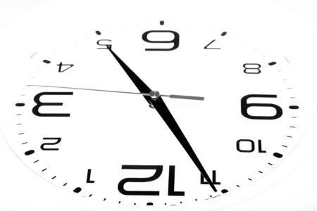 White wall clock with black arrows. Selective focus. Shallow depth of field. Toned.の写真素材