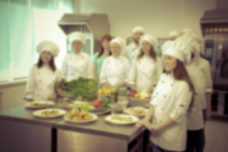 The team of cooks in the kitchen of the restaurant. Defocused. Toned.の写真素材