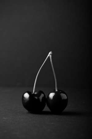 Cherry berries on black background. Selective focus. Shallow depth of field. Toned.の写真素材