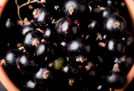 Currant berries in a clay bowl. Selective focus. Shallow depth of field.