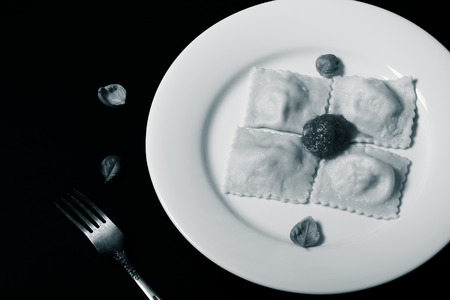 Russian ravioli - pelmeni with tomato sauce and basil on a white plate. Selective focus. Toned.の写真素材