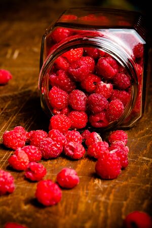 Lots of fresh bright red raspberries. Selective focus. Shallow depth of field. Toned.の写真素材