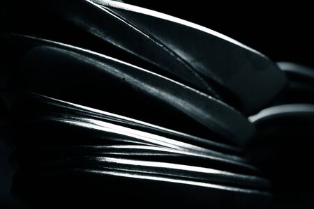 Lot of metal cutlery on a black background. Selective focus. Shallow depth of field. Toned.の写真素材