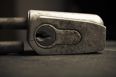 Old metal lock on a black background. Selective focus. Shallow depth of field. Toned.