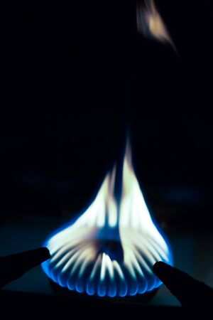 Gas burns on the burner on the stove in the dark. Selective focus. Toned.の写真素材