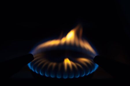 Gas burns on the burner on the stove in the dark. Selective focus.の写真素材