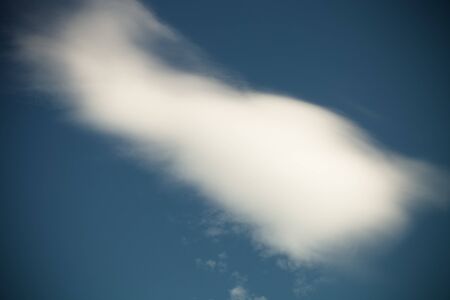 White clouds on a blue sky. Selective focus. Toned.