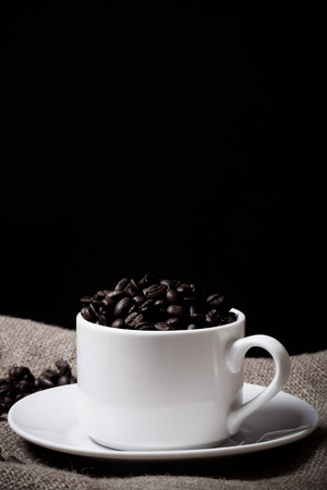 Coffee beans and coffee in cup on burlap. Selective focus. Toned.の写真素材