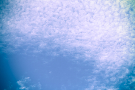 White clouds on a blue sky. Selective focus. Toned.