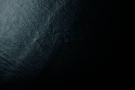 Black textured wall with varying light conditions. Background. Toned.の写真素材