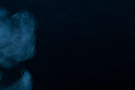 Cloud of smoke on black background. Selective focus. Toned.