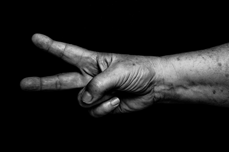 Hands of elderly woman on black background. Toned.の写真素材
