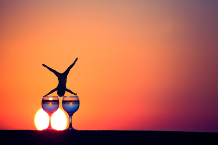 Glass of white vine with reflections of houses and view to beautiful sunset. Selective focus.の写真素材