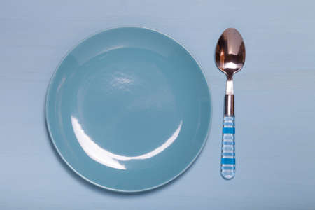 Plate and spoon  on a wooden background.