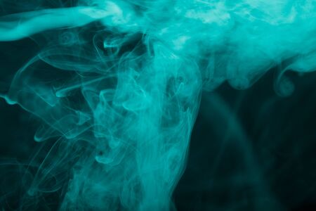 Cloud of smoke on black background. Selective focus. Toned.