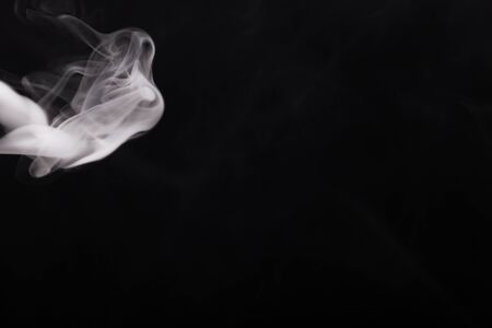 Cloud of smoke on black background. Selective focus.