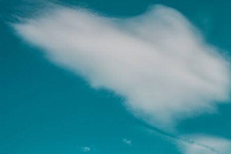 White clouds on a blue sky. Selective focus. Toned.