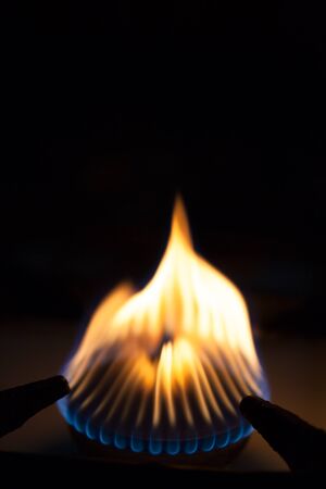 Gas burns on the burner on the stove in the dark. Selective focus.の写真素材