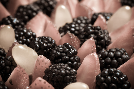 Top of biscuit homemade cake with cream and berries on black background. Selective focus. Shallow depth of field. Toned.の写真素材