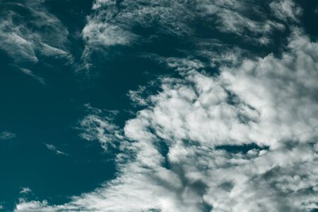 Blue sky with white cumulus clouds. Toned.の写真素材