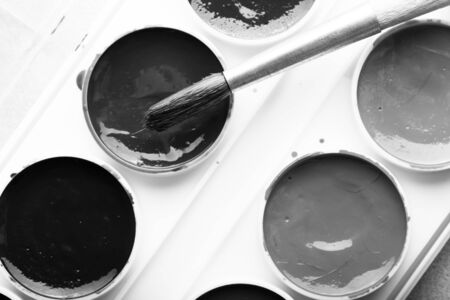 Colorful watercolor paints in palette with brush. Toned.の写真素材