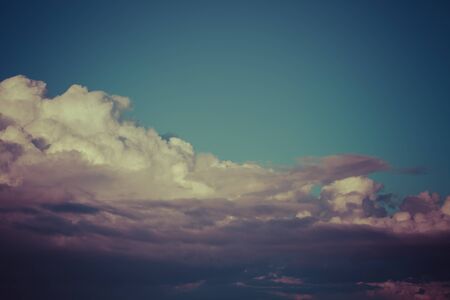 Blue sky with white cumulus clouds. Toned.の写真素材