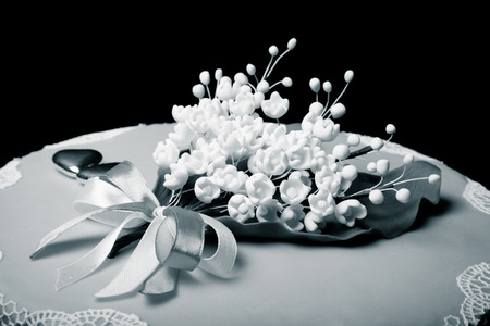 Wedding cake with lace and flowers on green background. Toned.の写真素材