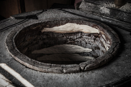 The process of baking bread in a traditional Georgian stove - tone (tandoor). Toned.