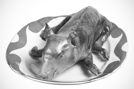 Roast suckling pig in the old porcelain dish. Toned.の写真素材