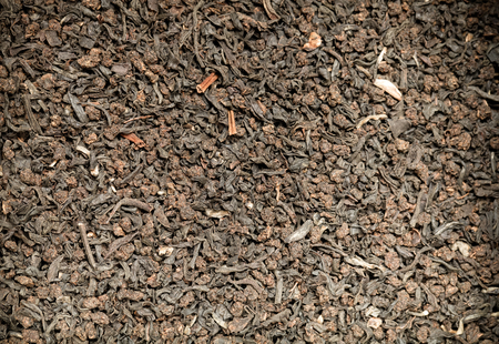 Dry black tea leaves as texture for background. Toned.の写真素材