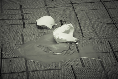 Broken eggs on the linoleum floor. Toned.の写真素材