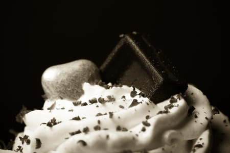 Vanilla cupcakes with orange and white creamcheese and chocolate decor. Selective focus. Shallow depth of field. Toned.の写真素材