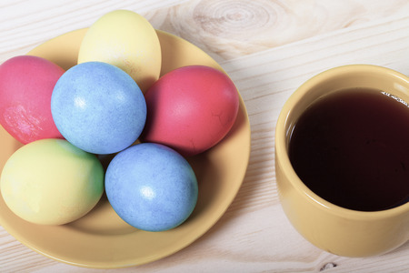 Easter eggs and cup of tea on light background. Toned.の写真素材